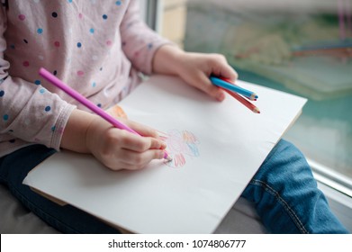 A child draws a flower with colored pencils - Powered by Shutterstock