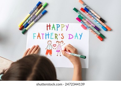 child draws a gift to dad for Father's Day, dad and daughter on a sheet with multi-colored felt-tip pens, top view - Powered by Shutterstock