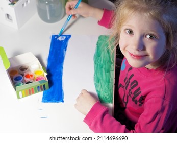 The Child Draws With Gouache Paints On A White Landscape Sheet With A Brush. Children's Creativity. Drawing With Paints. Art Therapy.