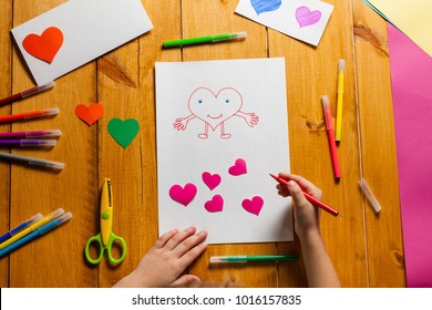 Child draws heart  Little boy making card for Valentine's Day  Top view 