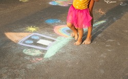 A Child Draws A House And A Rainbow On The Asphalt With Chalk. Selective Focus. Kid.