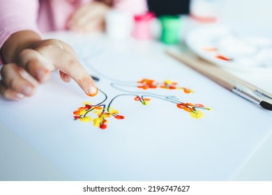 A Child Draws Leafs On A Tree. Ideas For Drawing With Finger Paints. Finger Painting For Kids On White Background. Little Girl Painting By Finger Hand Paint Color. Children Development Concept.