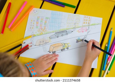 Child Draws A Pencil Drawing Of The City, Cars And Air Pollution. Top View.