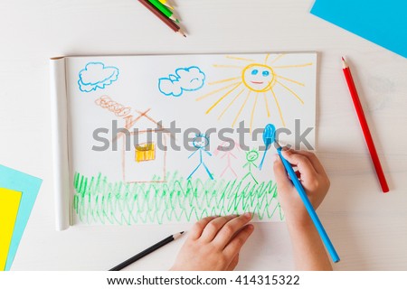 Child draws a pencil drawing of the house and his family. New home. Top view.