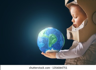 Child Is Dressed In An Astronaut Costume. Kid With Globe. Earth Day.