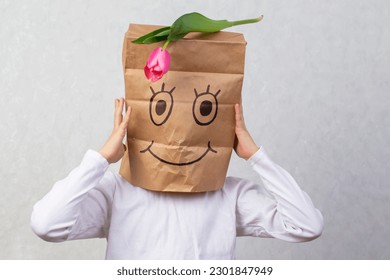The child drew smile paper bag   put it his head  The concept an anonymous gift 