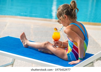 The Child Is Drinking A Cocktail By The Pool. Selective Focus. Kid.