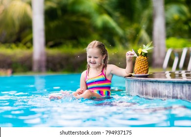 Child Drinking Juice In Swimming Pool Bar. Summer Family Vacation With Kids. Little Girl Holding Fresh Pineapple Cocktail In Swim Up Beach Cafe. Kid With Tropical Fruit Lemonade In Luxury Resort.