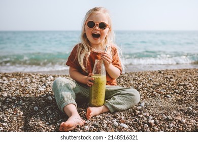 Child Drinking Smoothie On Beach Healthy Lifestyle Summer Vacations Child With Reusable Glass Bottle Vegan Organic Beverage Picnic Outdoor Kid Laughing Happy Emotions 