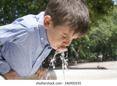 Child Drinking Water From A Fountain. Close Up