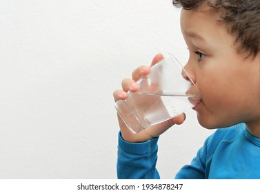 Child Drinking Water From A Glass With White Background Stock Photo