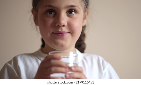 Child Drinking Water. Little Girl In The Kitchen Drinks Water From A Glass Cup. Problem Of Shortage Of Drinking Water In The World Concept. Kid Lifestyle Drinking Clean Water From A Glass