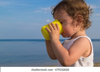 The Child Drinks Water In The Heat. Dehydration In The Sun