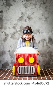 Child Driving A Car Made Of Cardboard Box. Kid Having Fun At Home. Travel And Vacation Concept