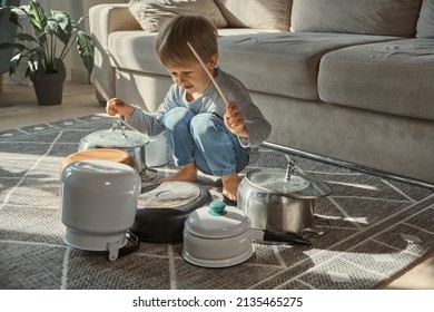 Child Drummer Having Fun Drum Playing On Kitchen Pans, At Home