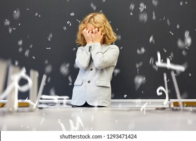 Child With Dyslexia In Front Of Blackboard In Elementary School