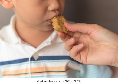 Child Eat Chicken Nugget Served By Mom