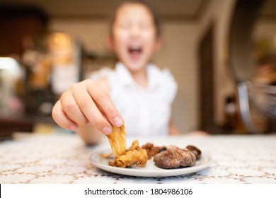 Child eating dried fruits in the kitchen - Powered by Shutterstock