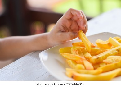 Child Eating French Fries Or Potato Chips.