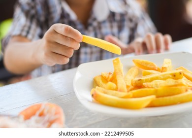 Child Eating French Fries Or Potato Chips.