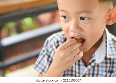 Child Eating French Fries Or Potato Chips.