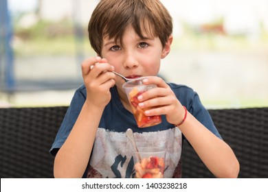 Child Eating Fruit From A Plastic Cup