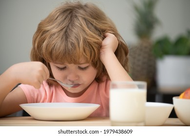 Child Eating Healthy Food At Home. Unhappy Child Have No Appetite. Upset Little Kid Refuse To Eat Organic Cereals With Milk. Baby Eat Soup With Spoon.