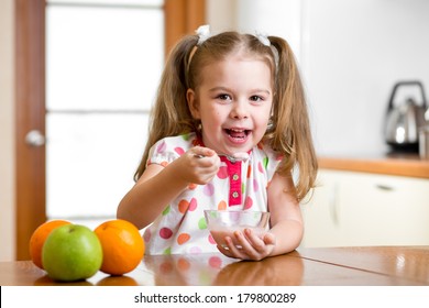 child eating healthy food in kitchen