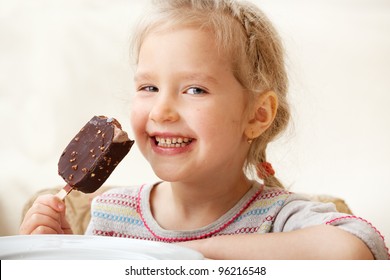 Child Eating Ice Cream. Little Girl At Home