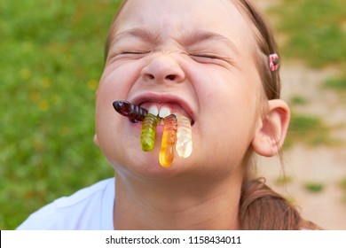 The Child Is Eating Jelly Candy Worms.