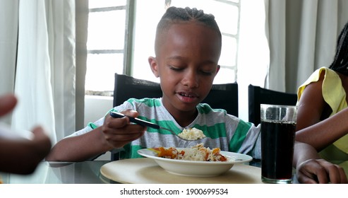 Child Eating Lunch. Black African Mixed Race Kid Eats Meal With Family