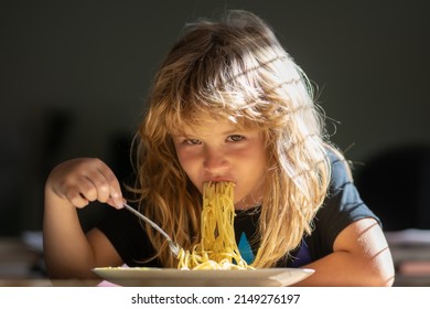 Child Eating On Blurred Background. Hungry Little Boy Eating. Home Food For Kids. Tasty Food, Messy Child Eating Spaghetti