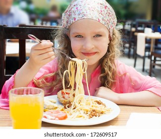 Child Eating Pasta At Cafe