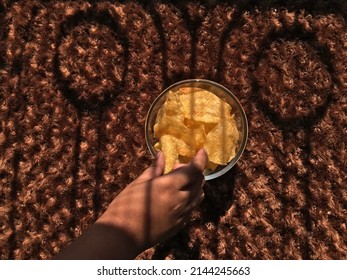 Child Eating Potato Chips In The Sun