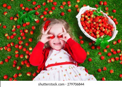 Child Eating Strawberry. Little Girl Playing Peek A Boo Holding Fresh Ripe Strawberries. Kids Eating Fruit Relaxing On A Lawn. Children Summer Fun On A Farm Picking Berry.