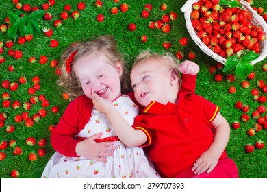 Child Eating Strawberry. Little Girl And Baby Boy Play And Eat Fresh Ripe Strawberries. Kids With Fruit Relaxing On A Lawn. Children Summer Fun On A Farm Picking Berry.