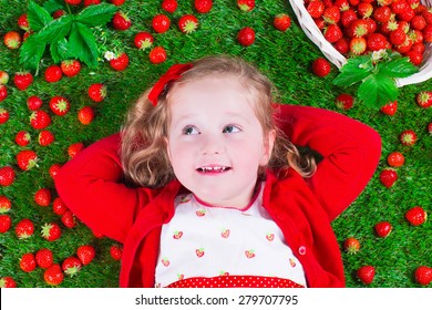 Child Eating Strawberry. Little Girl Playing Peek A Boo Holding Fresh Ripe Strawberries. Kids Eating Fruit Relaxing On A Lawn. Children Summer Fun On A Farm Picking Berry.