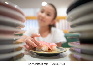 Child Eating Sushi At Conveyor Belt Sushi