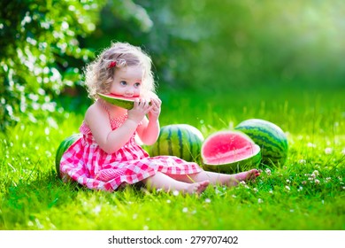 Child eating watermelon in the garden. Kids eat fruit outdoors. Healthy snack for children. Little girl playing in the garden holding a slice of water melon. Kid gardening. - Powered by Shutterstock