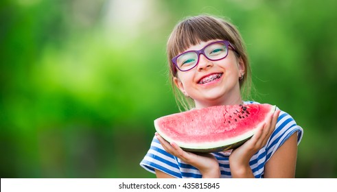 Child Eating Watermelon In Garden. Pre Teen Girl With Gasses And Teeth Braces. 