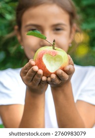 The child eats an apple in the garden. Selective focus. Kid.