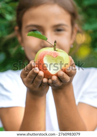 The child eats an apple in the garden. Selective focus. Kid.