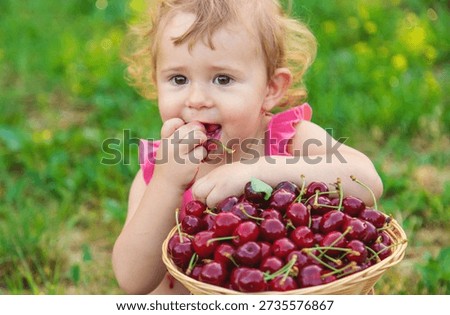 The child eats cherries in the garden. Selective focus. Food.