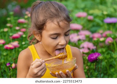 The child eats flower honey. Selective focus. Nature. - Shutterstock ID 2275513473