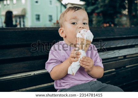child eats ice cream in a waffle cup on a bench in the park