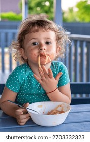 Child eats spaghetti pasta. Selective focus. Food.