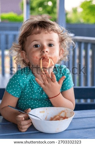 Child eats spaghetti pasta. Selective focus. Food.