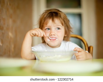 child eats with spoon in home