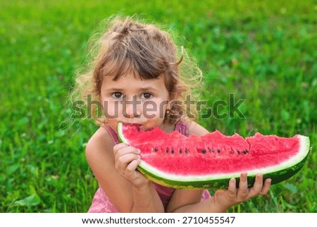 A child eats an watermelon in the park. Selective focus. Kid.