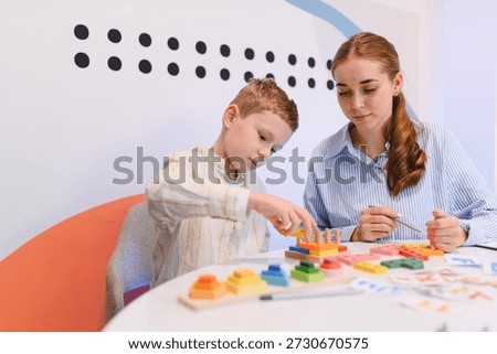 Child engaging with educational toys, developing fine motor skills and problem solving with a teacher